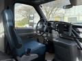 2002 Ford Econoline interior featuring a blue driver's seat and a simple dashboard with basic controls and a steering wheel