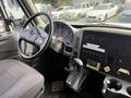 Interior of a 2011 International 4300 showing the driver's seat steering wheel dashboard and gear shift with various controls and gauges