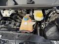 A 2017 RAM Promaster engine compartment with a coolant reservoir and a yellow cap visible alongside various engine components