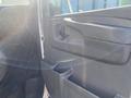 A 2011 Chevrolet Express van door interior featuring a black handle and storage compartments on the side