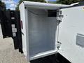 A white utility box on the back of a 2021 RAM 5500 truck with a partially open door revealing an empty interior