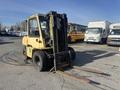 A 1993 Hyster H80XL forklift with a yellow exterior and two metal forks in front designed for lifting and transporting heavy loads