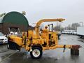 A yellow 1993 Bandit 200 wood chipper with a hopper a long discharge chute and a trailer hitch mounted on a wheeled frame