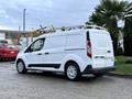 A white 2017 Ford Transit Connect van with a rear loading area and roof rack parked with the side door closed