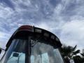 A 2005 Case 570 construction vehicle front view showing the cab roof with lights and a windshield