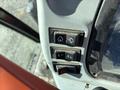 Control panel of a 2010 New Holland T4050 featuring three buttons for various functions including a home icon and an arrow symbol