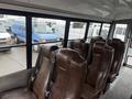Interior view of a 2021 Ford Econoline showing brown vinyl seats arranged in rows with a spacious seating layout
