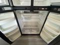 An open refrigerator with multiple shelves and compartments designed for storing food and beverages in a 2021 Grand Design Recreational ST3478MBS