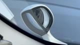 A white side mirror of a 2009 Toyota Vellfire reflecting light with a sleek, modern design