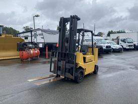 A yellow 2010 Hyster S80XLBCS forklift with two extended forks positioned at the rear
