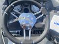 Steering wheel of a 2013 Larson 238 with a shiny chrome center and black grips alongside instrumentation gauges and control panel