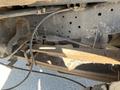 Underneath a 2016 Ford F-250 SD showing the suspension and frame components with visible rust and dirt on the metal parts