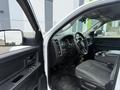 Interior view of a white 2016 RAM 1500 showing the dashboard steering wheel and front seats with a focus on the driver's side