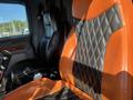 The image shows the interior of a 2009 Peterbilt Highway truck featuring two seats with orange and black leather upholstery in a diamond pattern