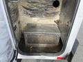 A 2015 Ford F-550 with an open storage compartment revealing a metal box with a perforated front and a rough interior surface