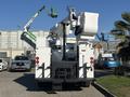 A white 2005 Freightliner M2 106 bucket truck with an elevated boom and platform at the rear, designed for utility work, with taillights visible