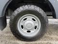 A close-up of a silver wheel and tire from a 2015 Ford F-350 SD featuring an all-terrain tread pattern