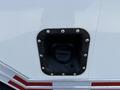 A close-up view of a black fuel filler opening with white screw rivets on a white surface of a 2019 Ford Econoline