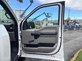 The image shows the open driver side door of a 2020 Ford F-150 featuring a gray interior panel with a handle and controls