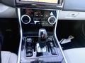 The interior console of a 2020 Jaguar XE featuring a gear shift lever climate control knobs and various buttons for audio and vehicle settings