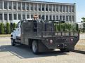 A 2005 GMC C7500 Topkick truck with a flatbed and custom equipment mounted on the rear including a toolbox and various apparatus