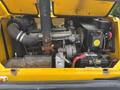 A yellow Bombardier SW48 engine with visible components including a large black air intake hose, a battery, and various mechanical parts inside an open compartment