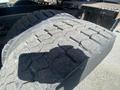 A close-up view of a large, used tire from a 1997 Freightliner FL70 showing noticeable tread wear and texture