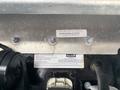 A metal plate with various labels and serial numbers securely fastened with screws to a surface on a 2020 Freightliner MT45 vehicle