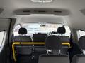 Interior view of a 2009 Toyota Hiace showing front seats and dashboard with a yellow bar across the back seat area