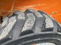 Close-up of a worn tire from a 2017 Gehl R105 featuring deep tread patterns and visible signs of use on the rubber surface