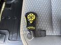 A wireless remote control with yellow buttons labeled NightRay is resting on a patterned fabric seat