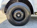Close-up of a black tire mounted on a wheel of a 2013 International CE300 with visible lug nuts and brand markings