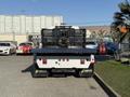 A 2017 International 4300 truck with a flatbed and rear dual exhaust pipes parked in a lot
