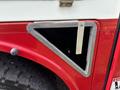 Close-up of a metal triangular frame with an open section on a red panel of a 2012 International 7300 Workstar truck