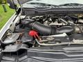 Close-up of the engine bay of a 2019 Ford F-350 SD featuring a black air intake hose and various engine components including the battery and coolant reservoir