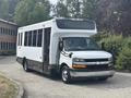 A 2020 Chevrolet Express, a white bus with a large front windshield and side windows, featuring a Chevrolet logo on the front grille.