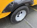 A close-up view of a tire mounted on a 2021 Ford Econoline showing a rim with five bolts and a rugged tread pattern
