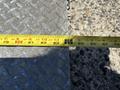 A measuring tape placed on a diamond plate surface displaying markings for inches up to 88 inches