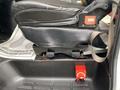 A leather driver's seat in a 2020 Chevrolet Express with a red emergency stop switch located on the floor next to the seat
