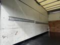 Interior view of a 2008 International CityStar truck showing a wooden floor and metal rails attached to the walls for securing cargo