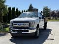 A 2019 Ford F-350 Super Duty pickup truck in white color with a flatbed and chrome grille parked on a driveway