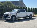 2023 Ford F-350 SD in white with a spacious cab and chrome accents parked on a street side