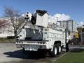 A 2008 International 7500 truck with a mounted aerial lift and storage compartment at the rear