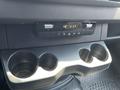 A dashboard console of a 2022 Mercedes-Benz Sprinter featuring climate controls and a cup holder with space for three drinks