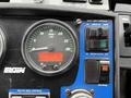 Dashboard of a 2009 UD Trucks UD 3300 featuring a speedometer with RPM gauge and control buttons for broom operations and pick-up head functions