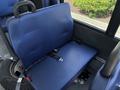 Interior view of a blue fabric seat with a seatbelt inside a vehicle designed for passenger transport