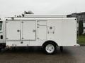 A white 2014 International TerraStar truck with a boxy cargo area featuring multiple doors and compartments in the side view