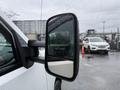 A close-up of the side mirror of a white 2013 Chevrolet Silverado 3500HD showing rain droplets on the glass