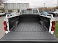 A 2015 GMC Sierra 1500 truck bed with a black bed liner and metal side rails
