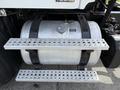 A silver fuel tank with a sturdy mounting system featuring perforated steps attached to a 2016 Freightliner 108SD truck